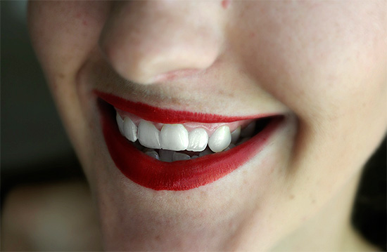 Wenn Sie Ihre Lippen mit leuchtend rotem Lippenstift bemalen, sehen die Zähne auf ihrem Hintergrund weißer aus ...