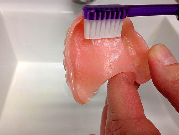 Verzorg het kunstgebit met een gewone tandenborstel en tandpasta.